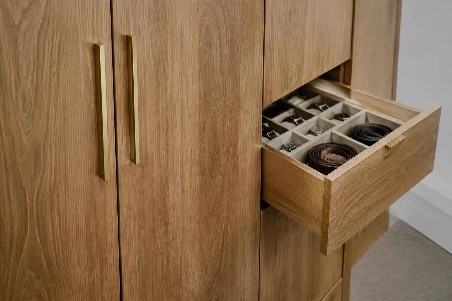 Oak wardrobe doors with brass handles and an open accessory drawer