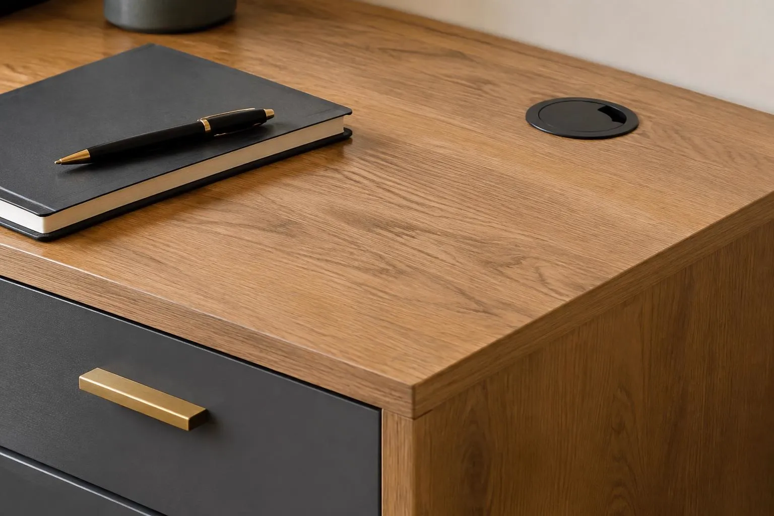 Oak desk surface with cable grommet and charcoal drawer with brass pull